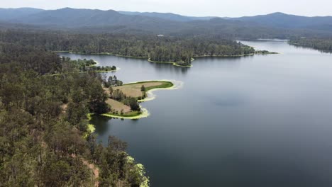 Vista-Aérea-De-Un-Hermoso-Lago-Con-Montañas-Al-Fondo