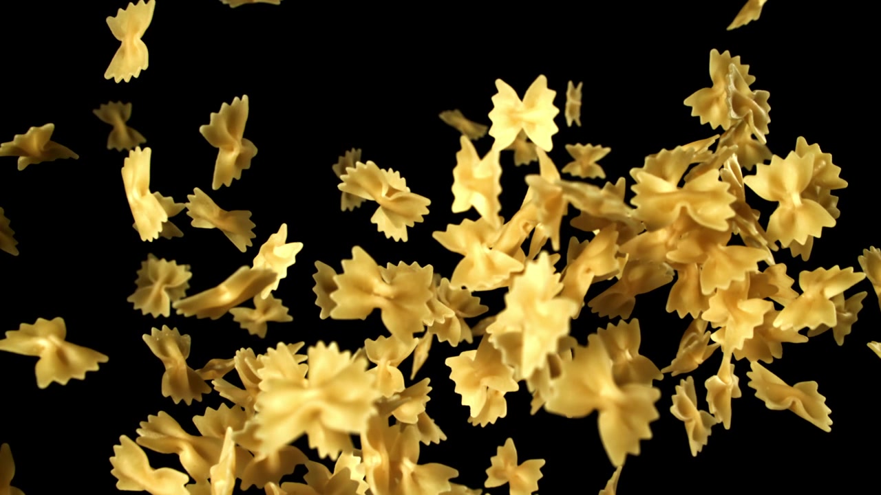 Pasta farfalle che cade al rallentatore su sfondo nero