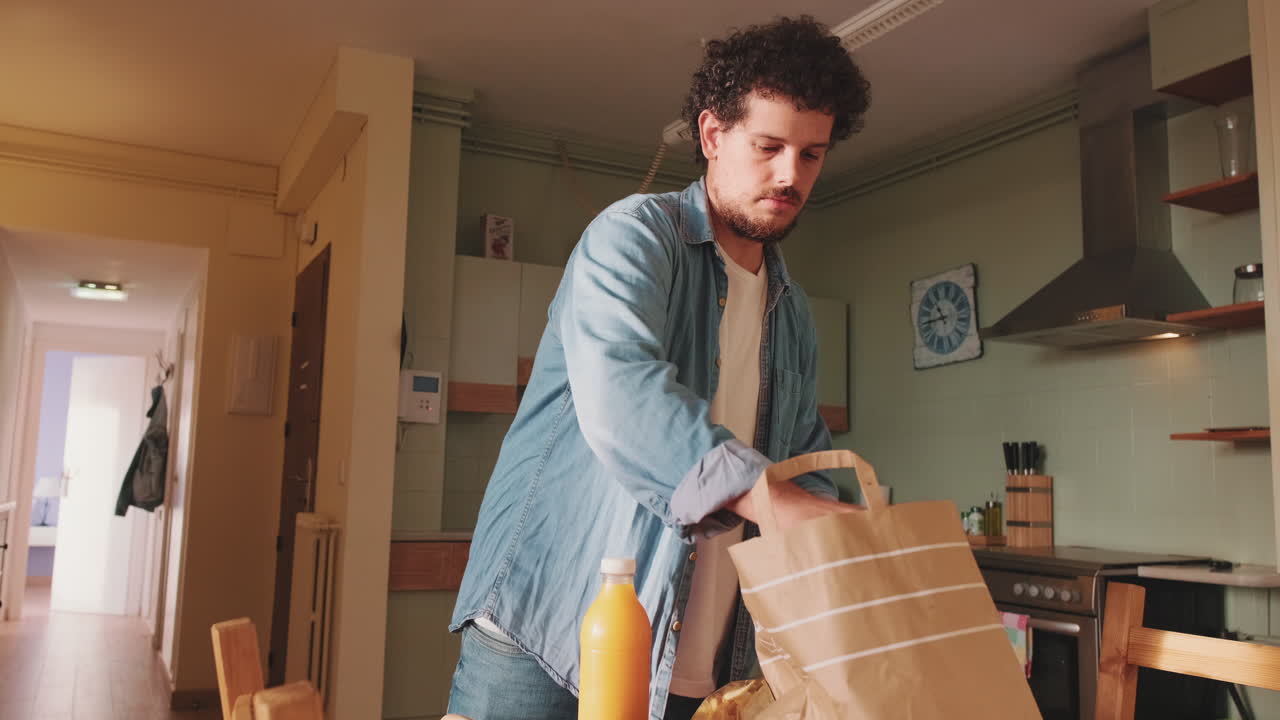 Man unpacking groceries in kitchen