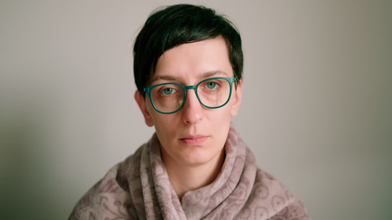 병을 느끼는 안경을 쓴 슬픈 여성의 클로즈업 얼굴