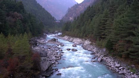 a beautiful glacier river running in the valley between the rugged mountains of the himalayas of nepal