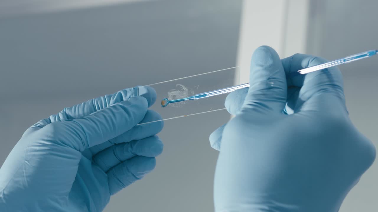 Scientist adding virus sample on glass for observing in a modern research laboratory