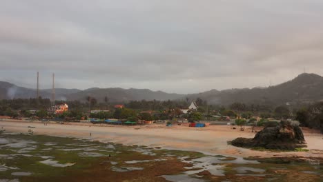 The-dry-reef-of-Kuta-Lombok-during-sunrise,-with-local-people-looking-for-food-and-seashells