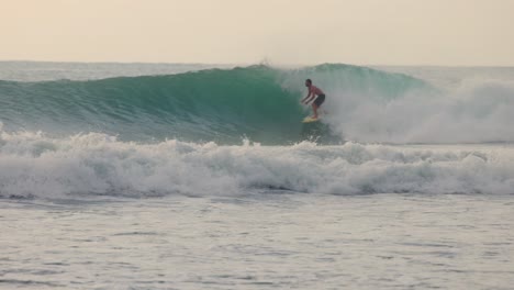 Slow-motion-shot-of-a-person-surfing-professionally-in-turquoise-waters-and-with-big-waves-in-Mexico