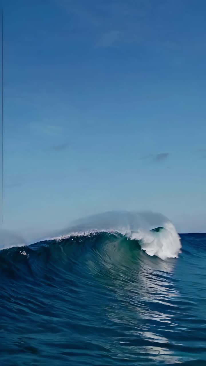 A serene video capturing a powerful ocean wave under a clear blue sky, showcasing nature's beauty