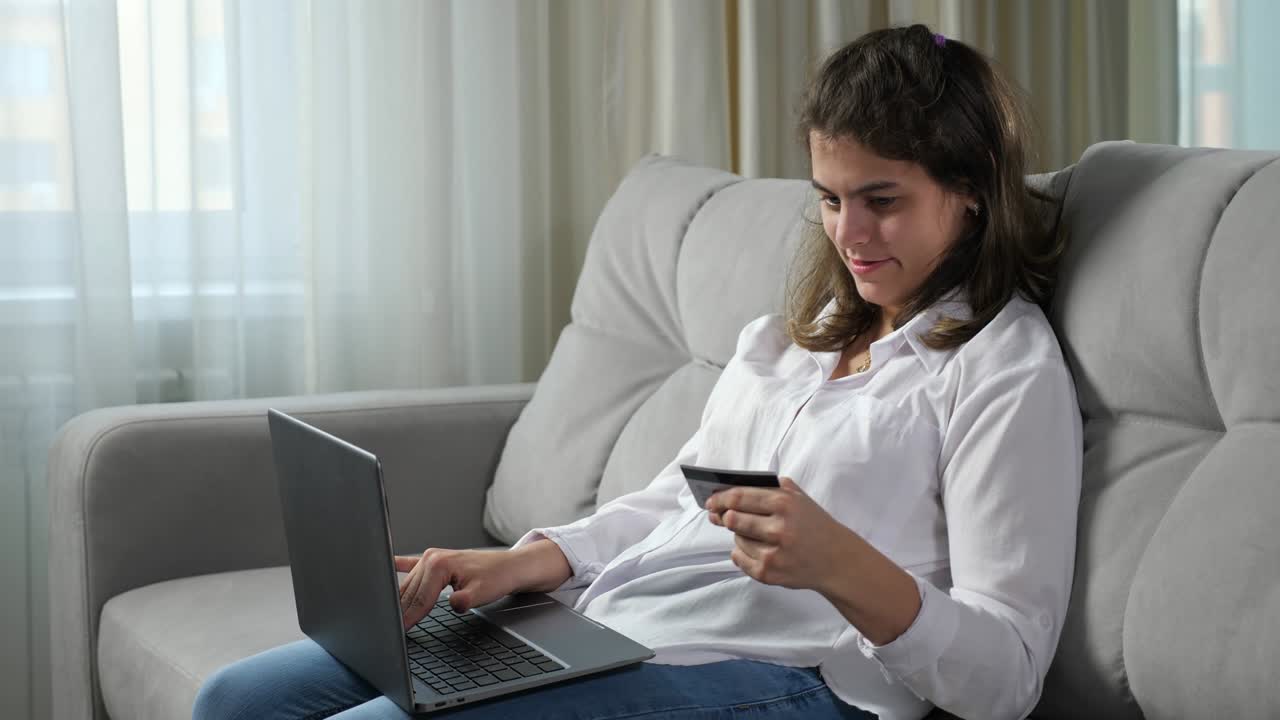 donna disabile inserisce i dettagli della carta bancaria sul portatile a casa