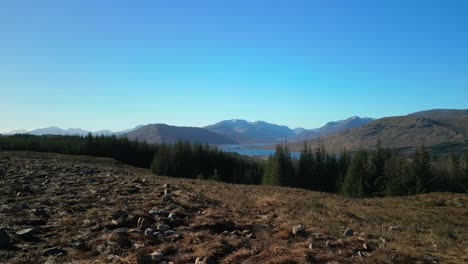 Volar-Más-Allá-Del-Excursionista-Con-Vistas-Al-Lago-Loyne-Y-Al-Bosque-De-Pinos-En-Las-Tierras-Altas-Escocesas