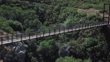 disparo de un dron siguiendo a un hombre activo corriendo en un puente colgante colgante al aire libre sobre el cañón del oso en draper city, utah-4