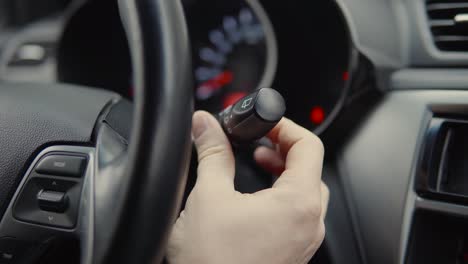 persona que ajusta los controles del limpiaparabrisas del coche