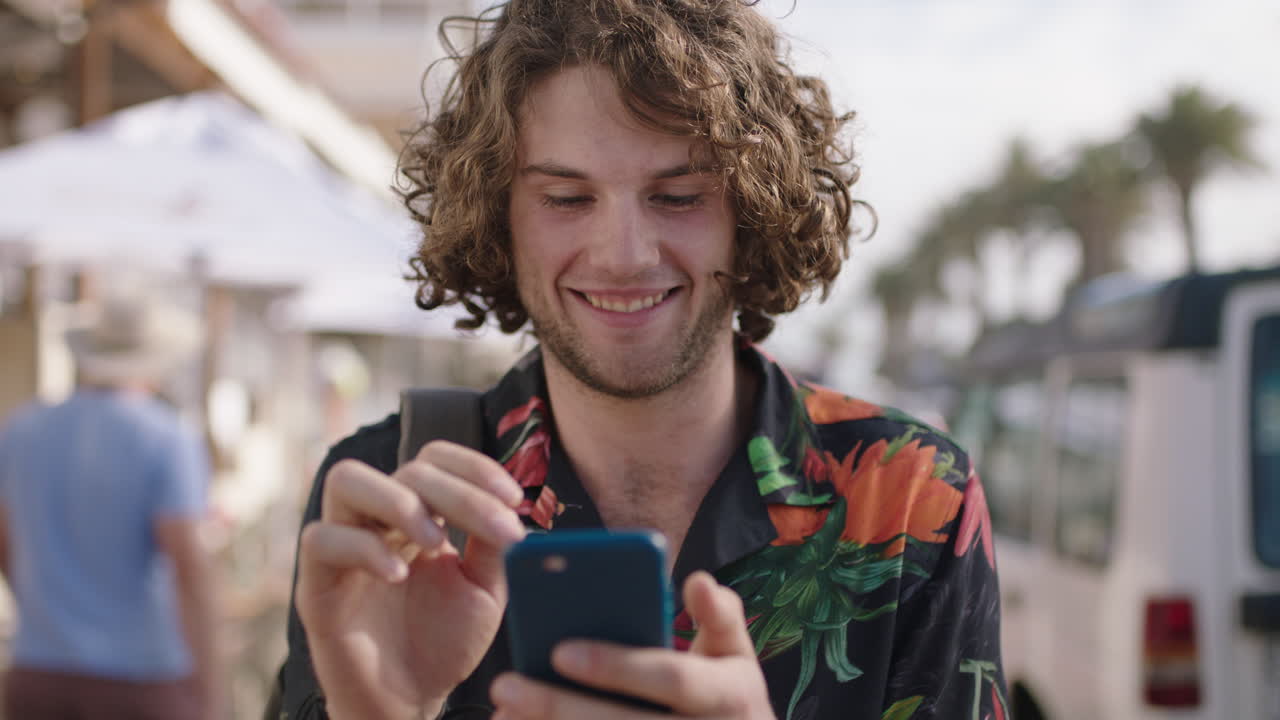 portrait of young attractive man using phone enjoying vacation wearing hawaiian shirt