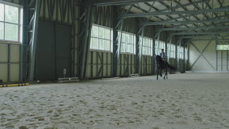 equestrian training session in a large indoor riding arena
