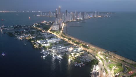 Drone-Aéreo-Sobre-Cartagena-Colombia-En-La-Noche-Bocagrande-Rascacielos-Costa-Península-Vista-Idílica,-Viajes-Y-Turismo-Establecimiento-Tiro