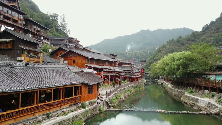 schwenk über den fluss und die stadt in qiandongnan, provinz guizhou, china, zeitlupe mit hoher geschwindigkeit