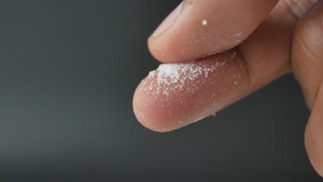 close up of someone's finger holding salt