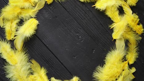 Colorful-decorative-Easter-feather-wreath-on-black-wooden-table-background