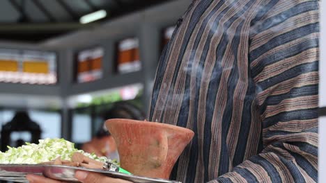 javanese man burning incense before the traditional procession