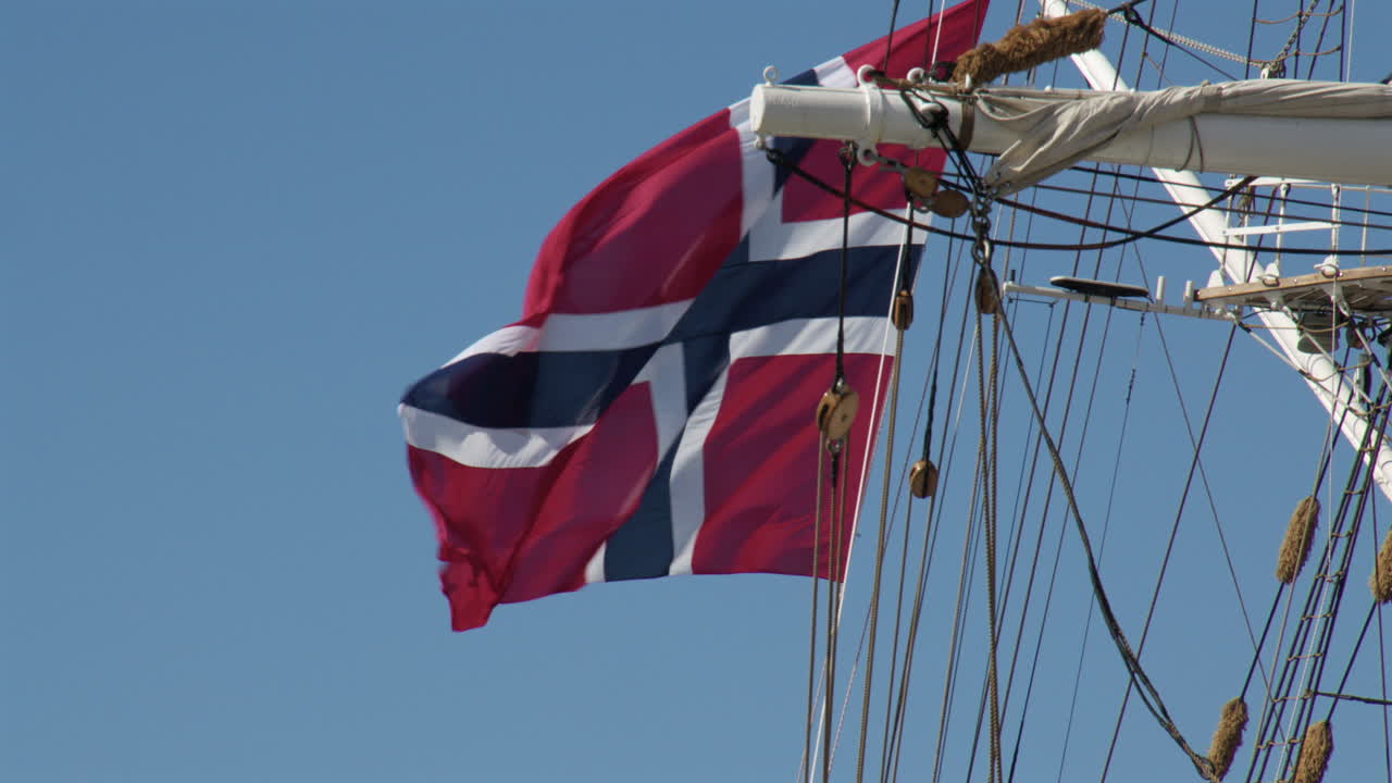 Mid shot of the Norwegian flag on the rigging of a tall ship at bergen