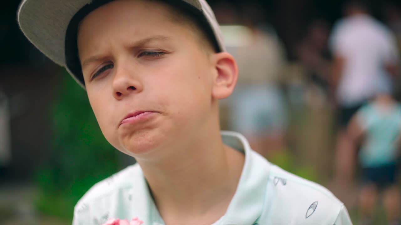 귀여운 배고픈 단 것을 좋아하는 아이가 설탕 프로스팅을 곁들인 머핀을 물었습니다.