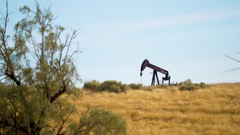 4k-working-oil-rig-with-fore-ground-on-the-left-side-in-hot-conditions-Central-California