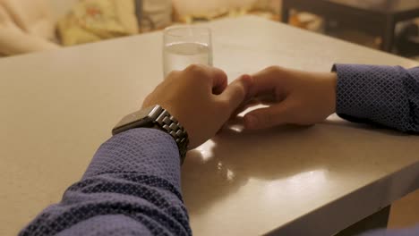 persona sentada en una mesa con un vaso de agua