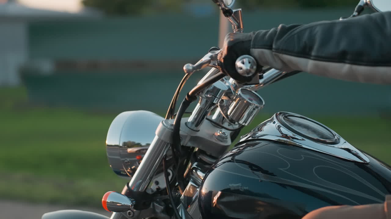 오토바이 앞바퀴와 크롬 부품을 클로즈업한 사진이에요. 도로를 달리며 모험을 즐기는 동안 저녁 햇살이 반사되는 반짝이는 금속과 흐릿한 녹색 배경이 바이커 라이프스타일의 정수를 담아내고 있어요.