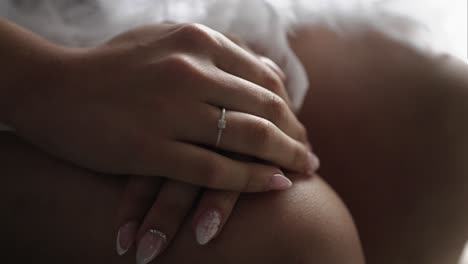 soft morning light illuminates delicate engagement ring on relaxed hand