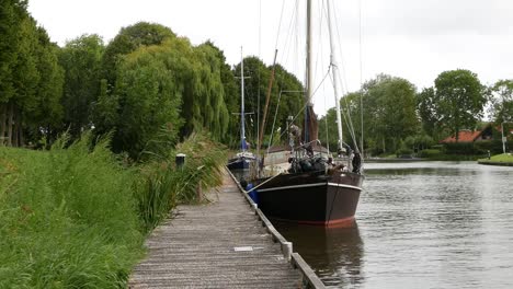 sailing boat moored by wooden jetty in canal