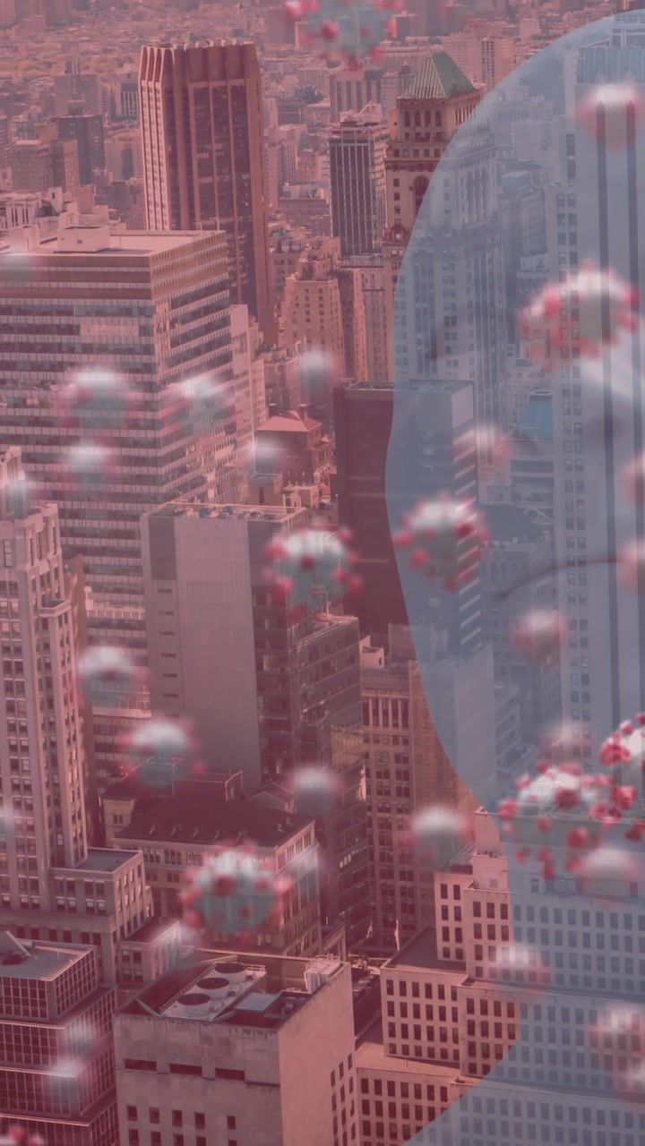 Animation of covid 19 cells floating over human head and cityscape on red background