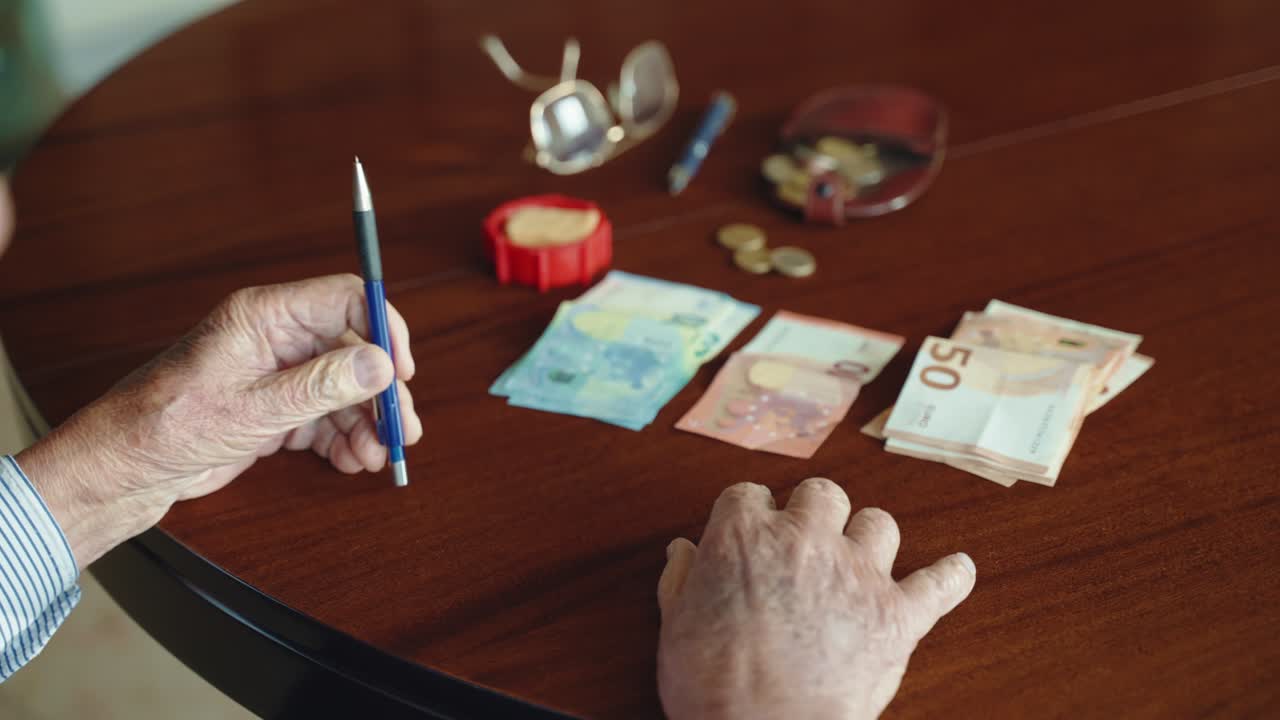 viejo hombre de negocios y empresario sentado en la mesa dest en la oficina y la planificación de su presupuesto contando los ingresos y gastos mensuales, el hombre mayor ahorrando dinero de negocio para la vejez y las inversiones, concepto