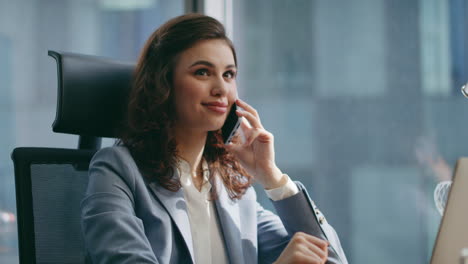 girl business consultant calling sitting office desk with laptop close up.