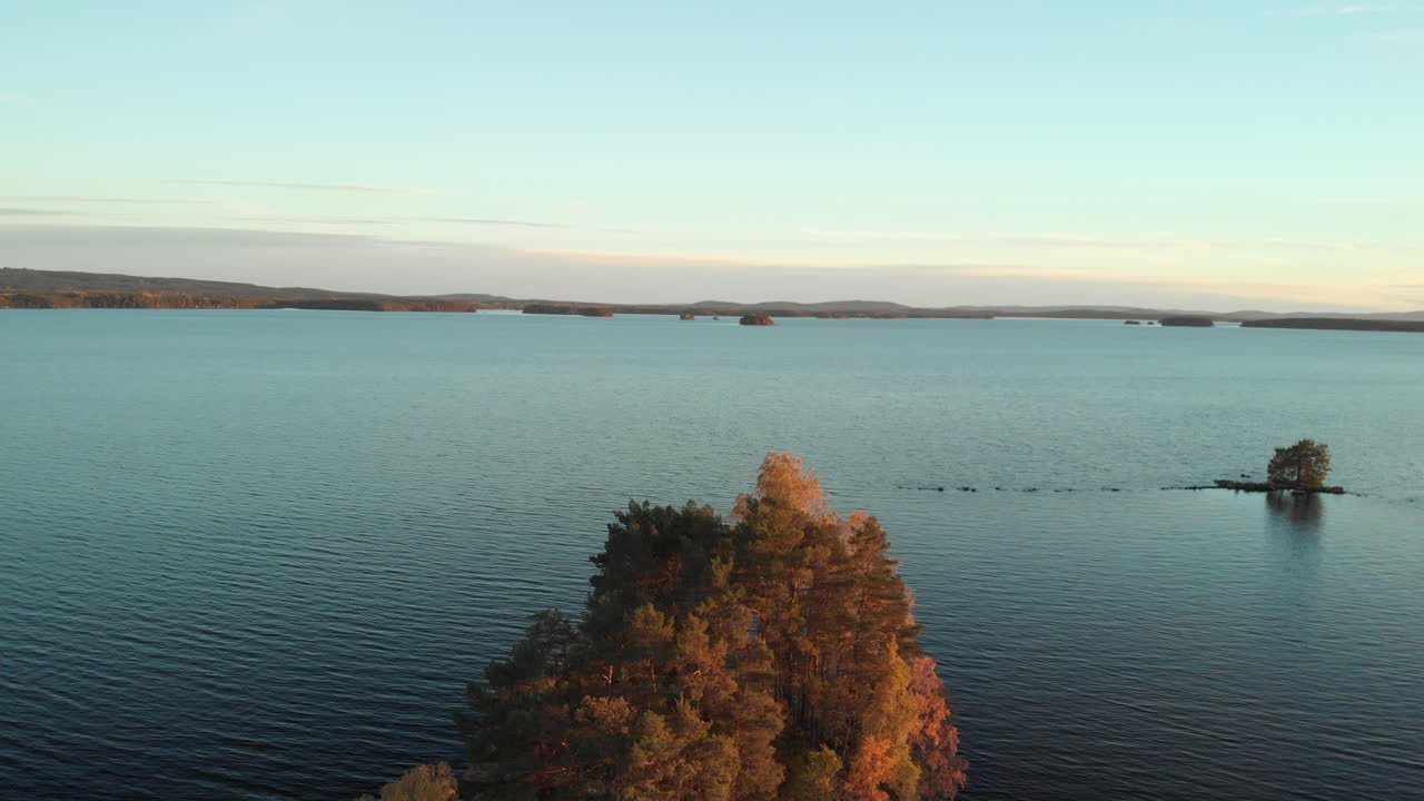 выявление красивого маленького острова, полного деревьев с оранжевыми листьями, посреди спокойного озера