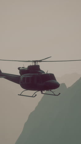 black helicopter flying over mountains