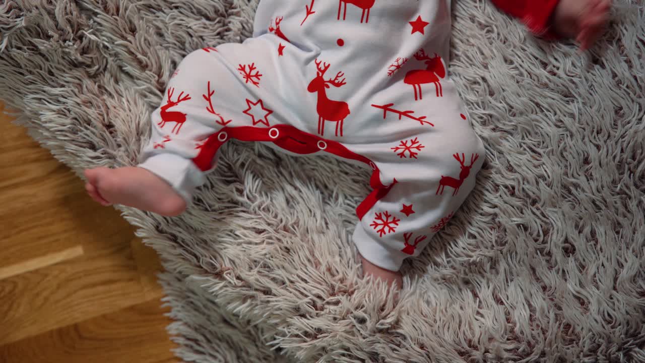 filmando desde arriba los movimientos de las piernas del bebé con ropa de año nuevo
