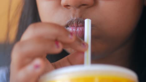 a woman drinks from a cup using a straw