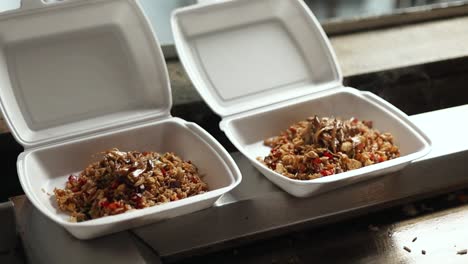 preparing fried rice in takeout containers