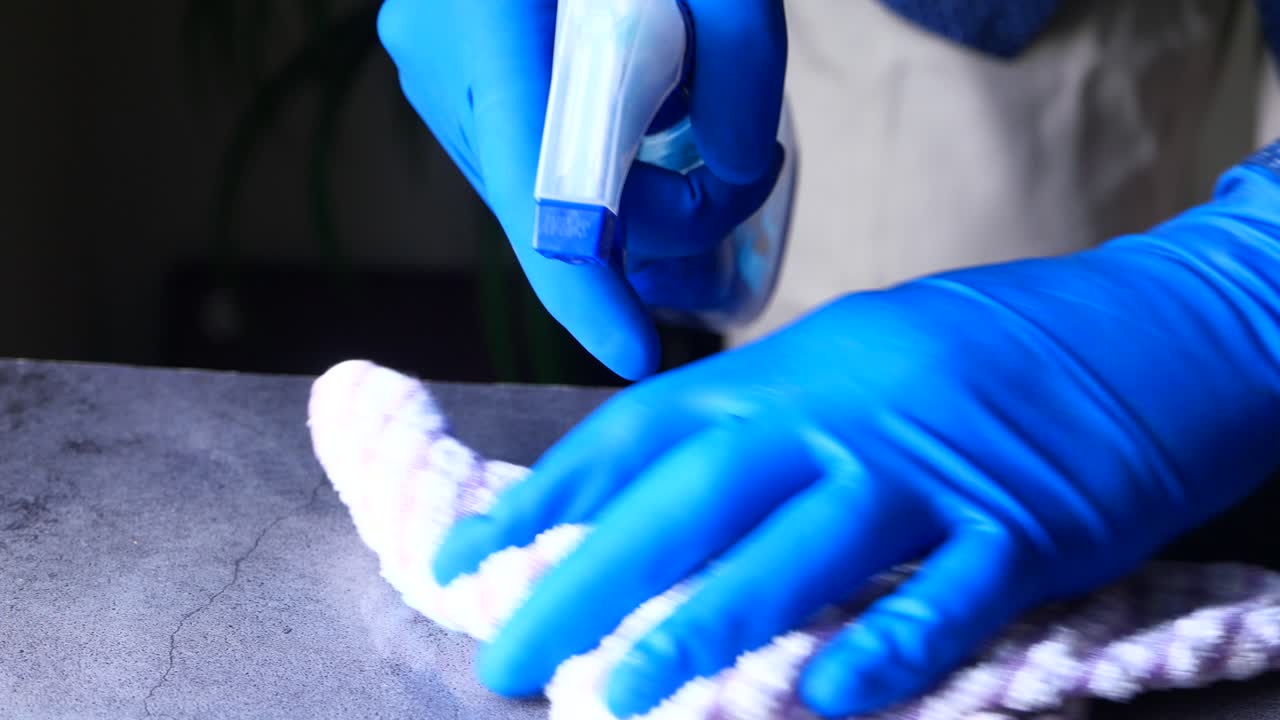 limpieza de un mostrador con una botella de spray y un paño