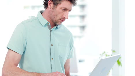 Smiling-businessman-using-a-laptop