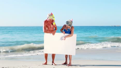 pareja de ancianos jubilados con un cartel blanco