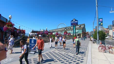 tourists walk on street of seattle city, sunny summer holiday day, washington state, west coast of the united states of america