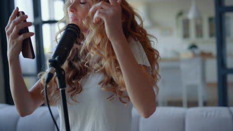 mujer atractiva cantando en el micrófono. cantante que se mueve al ritmo de la música
