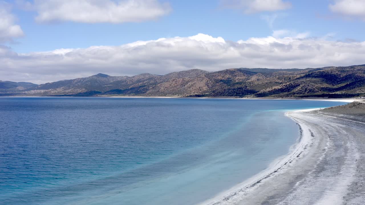 Scenic view to Turkish hills over deserted white beach and turquoise Lake