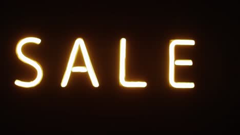 Composition-of-neon-sale-text-on-black-background