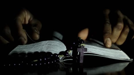 hombre rezando a dios con las manos juntas sobre fondo negro con la gente almacen de video