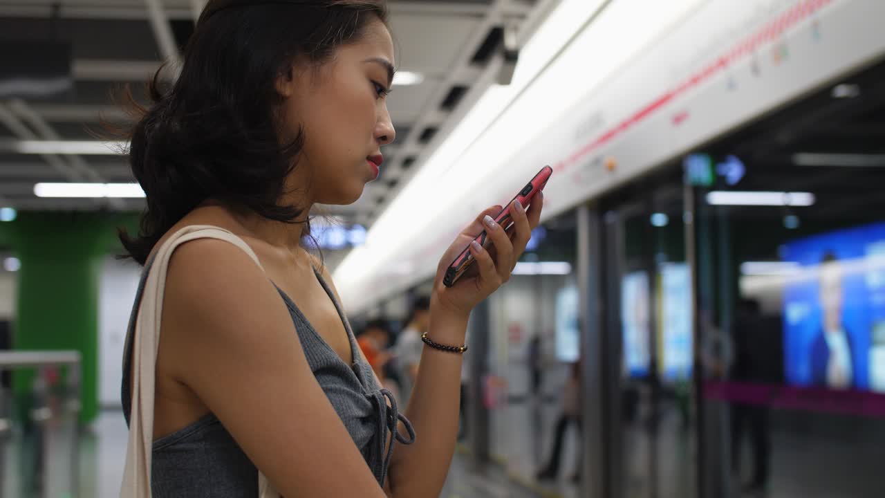 지하철역에서 전화를 사용하는 젊은 여성,4k