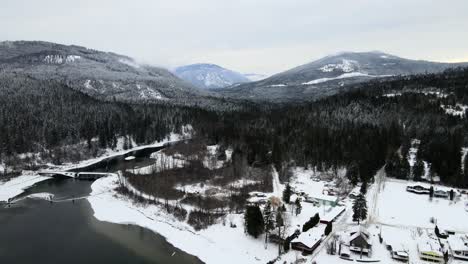 Spektakuläre-Aussicht-Auf-Die-Winterlandschaft-Des-Adams-Lake-Und-Verschneite-Wälder,-Luftdrohnenaufnahme-Mit-Bewölktem-Himmel