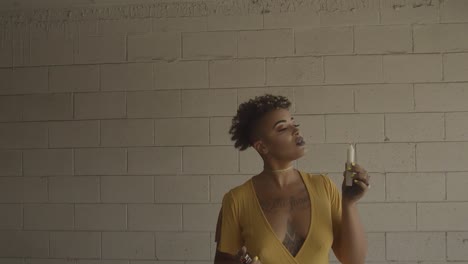 a beautiful woman with a tattoo lights a candle and lets the wax drip provocatively on herself as she smiles