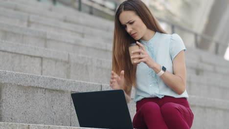 Businesswoman-working-on-laptop-in-city.Employee-reading-business-papers-outside