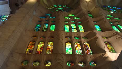 Pan-down-of-the-morning-stain-glass-window-at-La-Sagrada-Familia-Church,-Barcelona