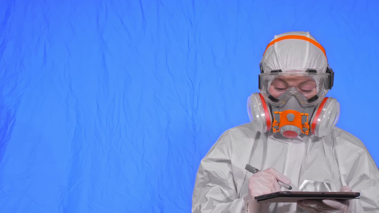 인공호흡기에서 바이러스학자 과학자는 태블릿 컴퓨터에 스타일러스를 사용해 글을 쓴다. 보호 의료 마스크를 착용한 여성. 크로마 키 블루.