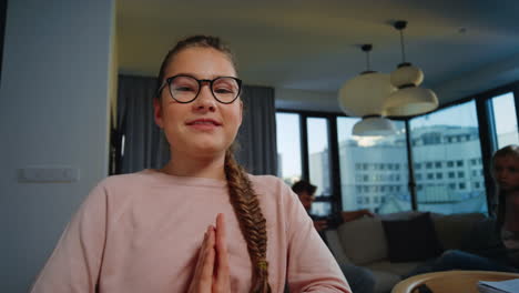 Clever-schoolgirl-learning-at-home.-Teen-girl-waving-hand-to-web-camera-indoors